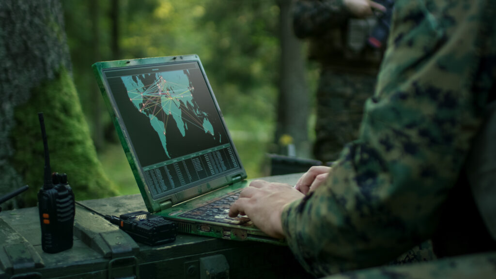 Soldier viewing a world map on a computer in the forest
